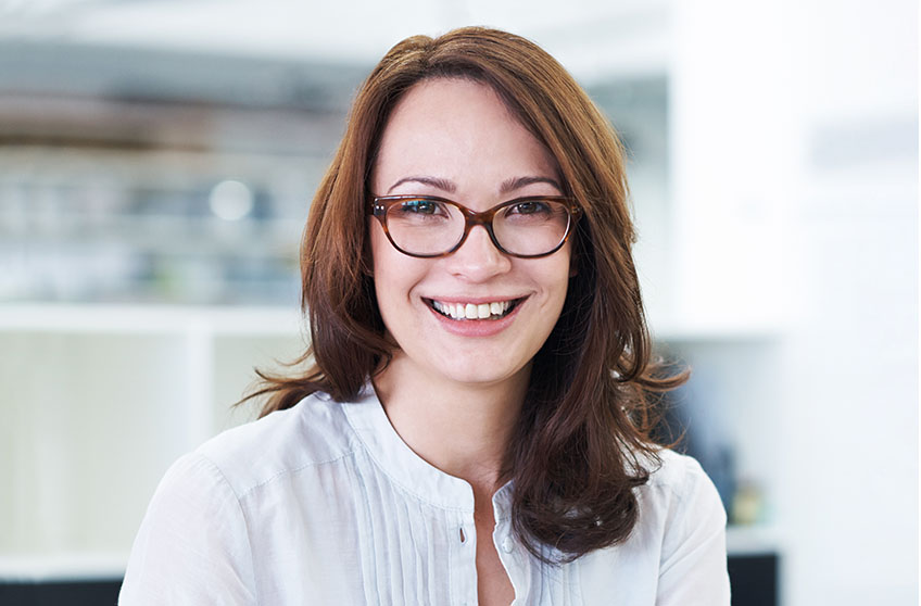 Headshot of future staff member, a woman wearing a white shirt in an office.